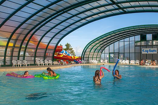 Piscina cubierta, tobogán y niños en el camping CAPFUN Falaises en Gonneville sur Mer.