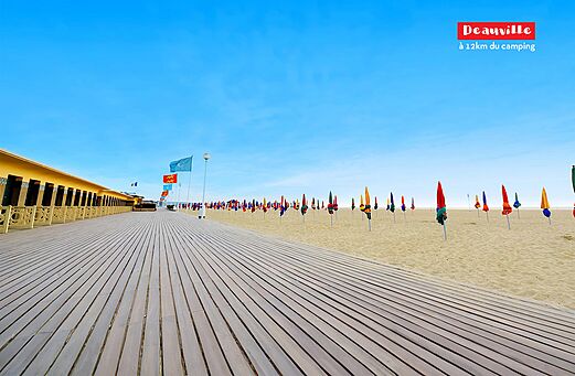 Famoso paseo marítimo de Deauville y playa con sombrillas de colores en Normandía.