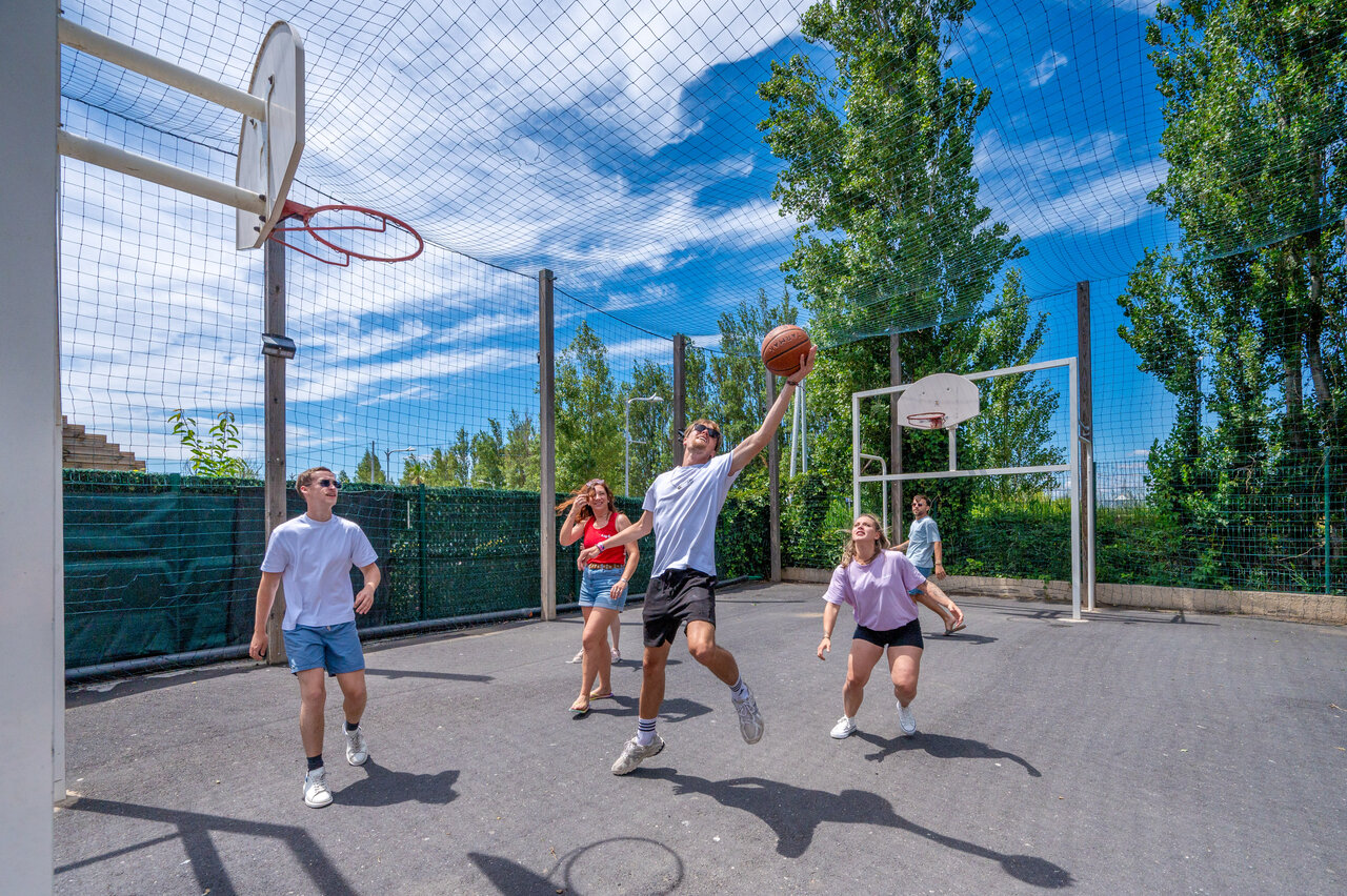 J�venes jugando baloncesto en cancha multideporte en CAPFUN F�erix MARSEILLAN PLAGE.