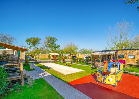 Zona de juegos colorida, pista de petanca y Mobil-homes en el camping CAPFUN Féerix en MARSEILLAN PLAGE (34).