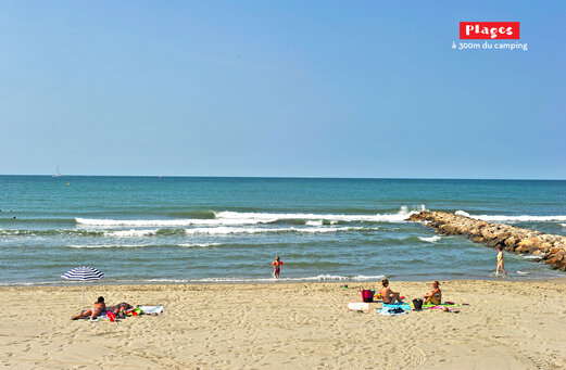 Playa de arena fina con mar y sombrilla en el camping CAPFUN Féerix en MARSEILLAN PLAGE (34).