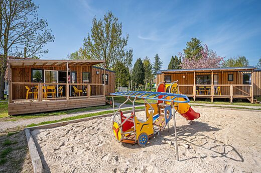 Zona de juegos y Mobil-homes en el camping CLICOCHIC Ferme des Aulnes en NAMPONT SAINT MARTIN (80).