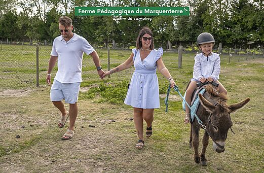 Niño montando burro en la Granja Pedagógica de Marquenterre, cerca del camping.