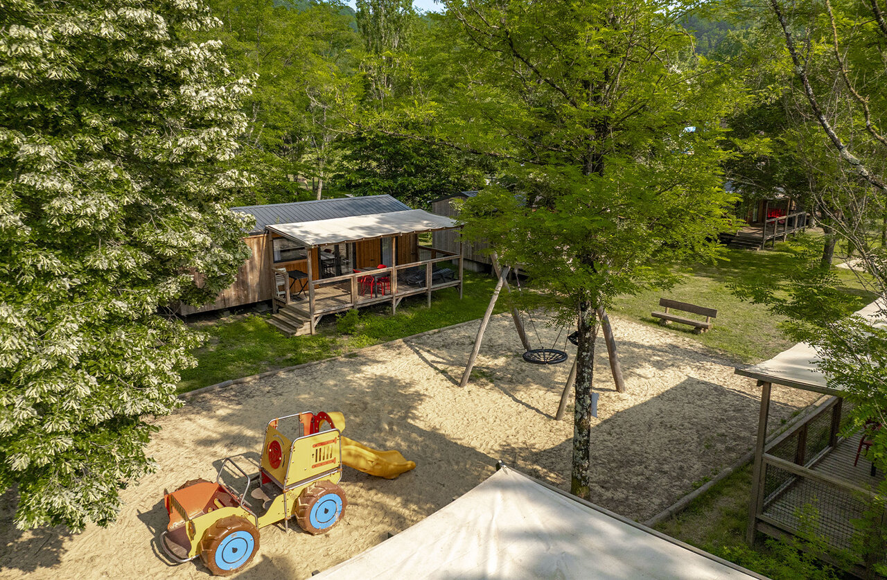 Zona de juegos arena, columpio, tractor, casas m�viles en el camping CLICOCHIC Filament en Thoiras.