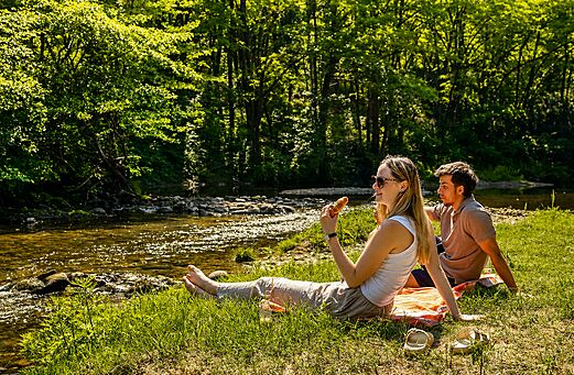 Pareja relaj�ndose a orillas de un r�o natural en el camping CLICOCHIC Filament en Thoiras (30).