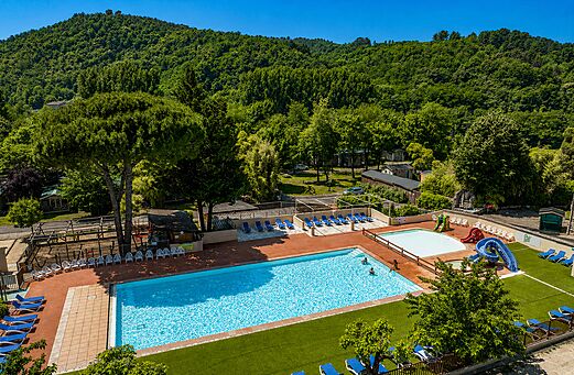 Piscina exterior con toboganes y sillas en el camping CLICOCHIC Filament en Thoiras (30).