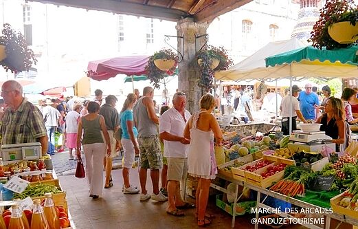 Animado mercado de las Arcadas con puestos de productos frescos en Anduze, Gard.