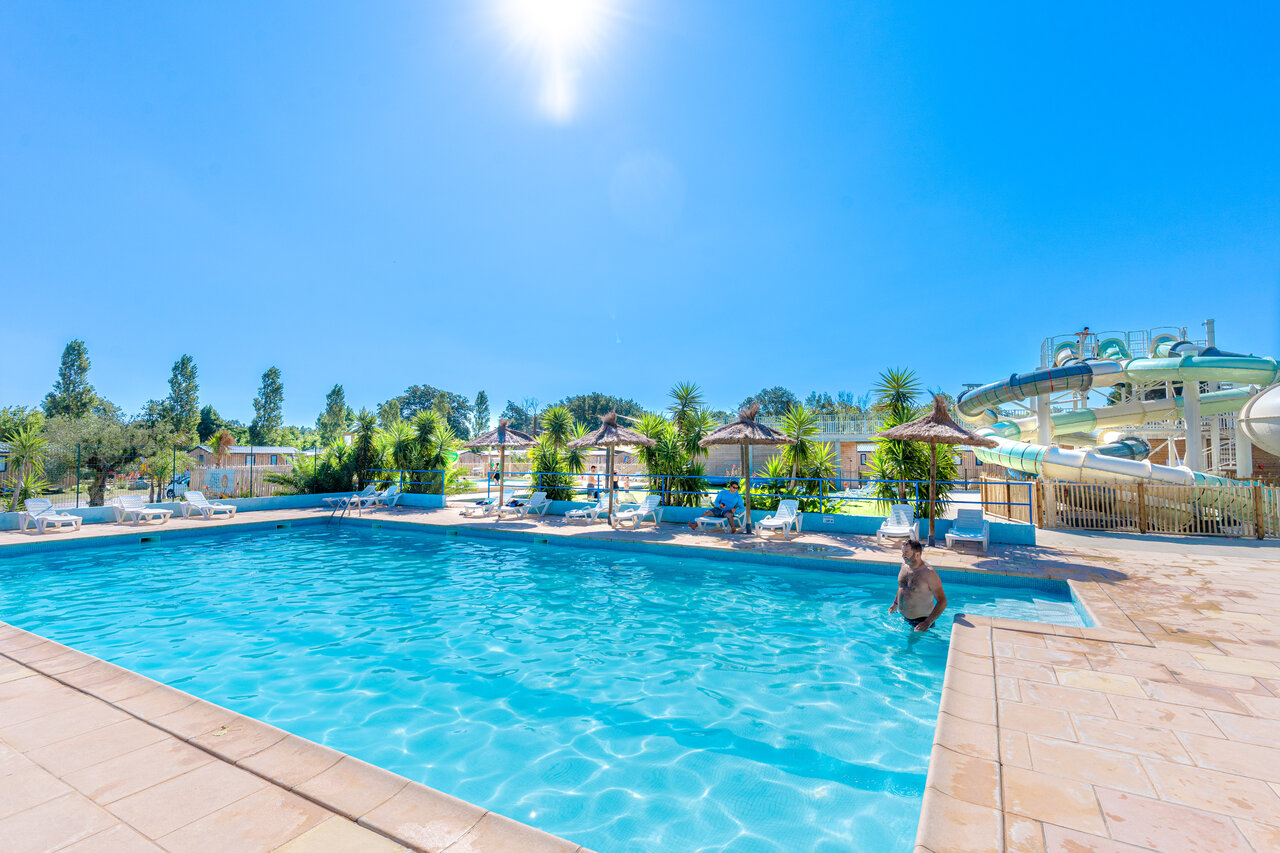 Piscina exterior con toboganes acu�ticos y tumbonas en el camping VAGUES OCEANES Au Flamenco en Argel�s-sur-Mer (66).