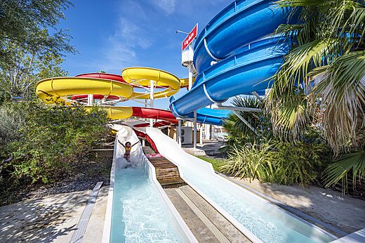 Toboganes acu�ticos coloridos y ni�o desliz�ndose en camping CAPFUN Fleurs d'Agde en AGDE (34).