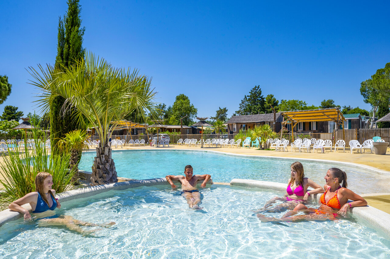 Familia relaj�ndose en la piscina exterior del CAPFUN Fleur de Camargue (30).