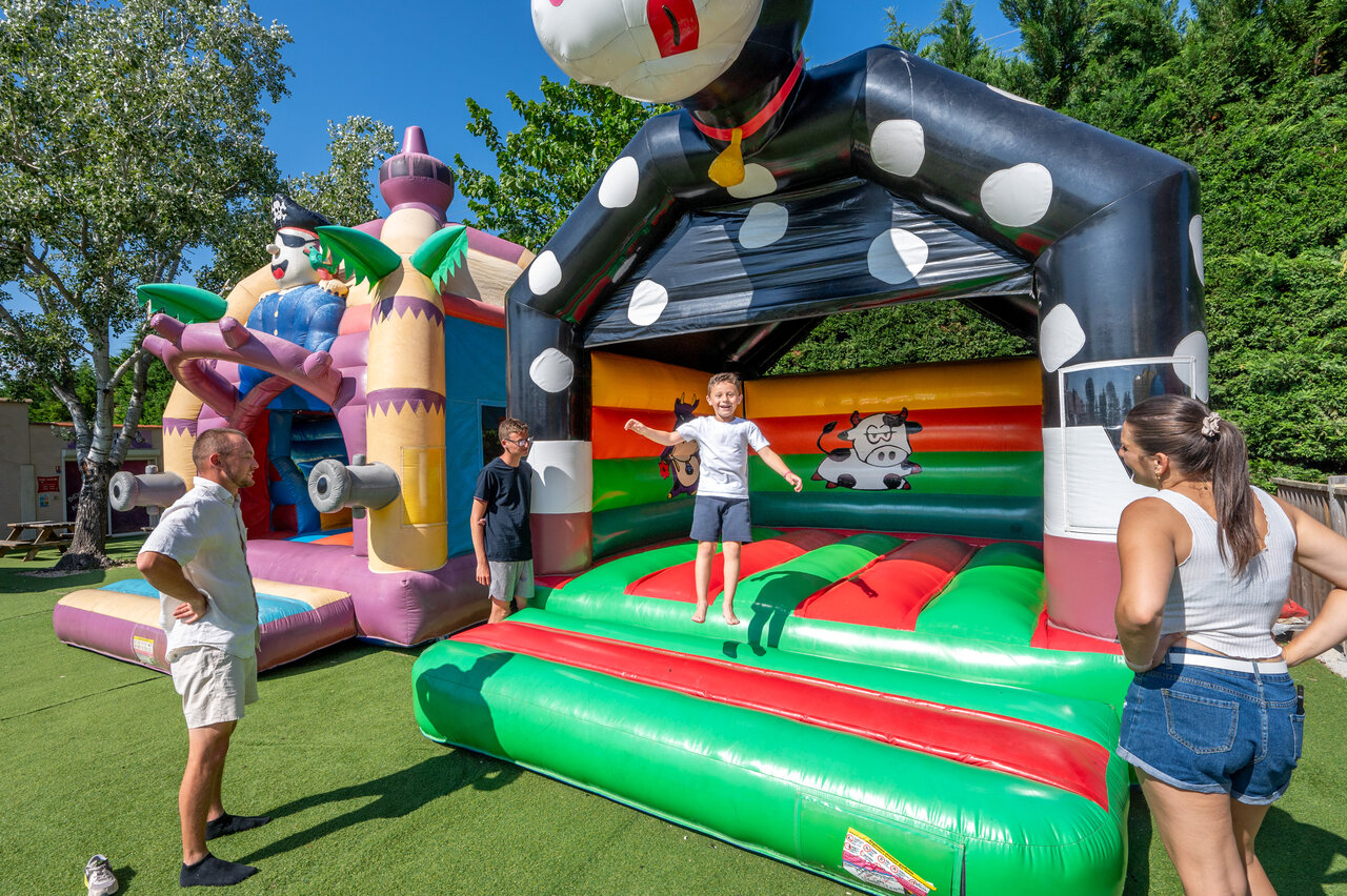 Ni�os divirti�ndose en castillos hinchables coloridos en el camping CAPFUN Fleur de Camargue (30).
