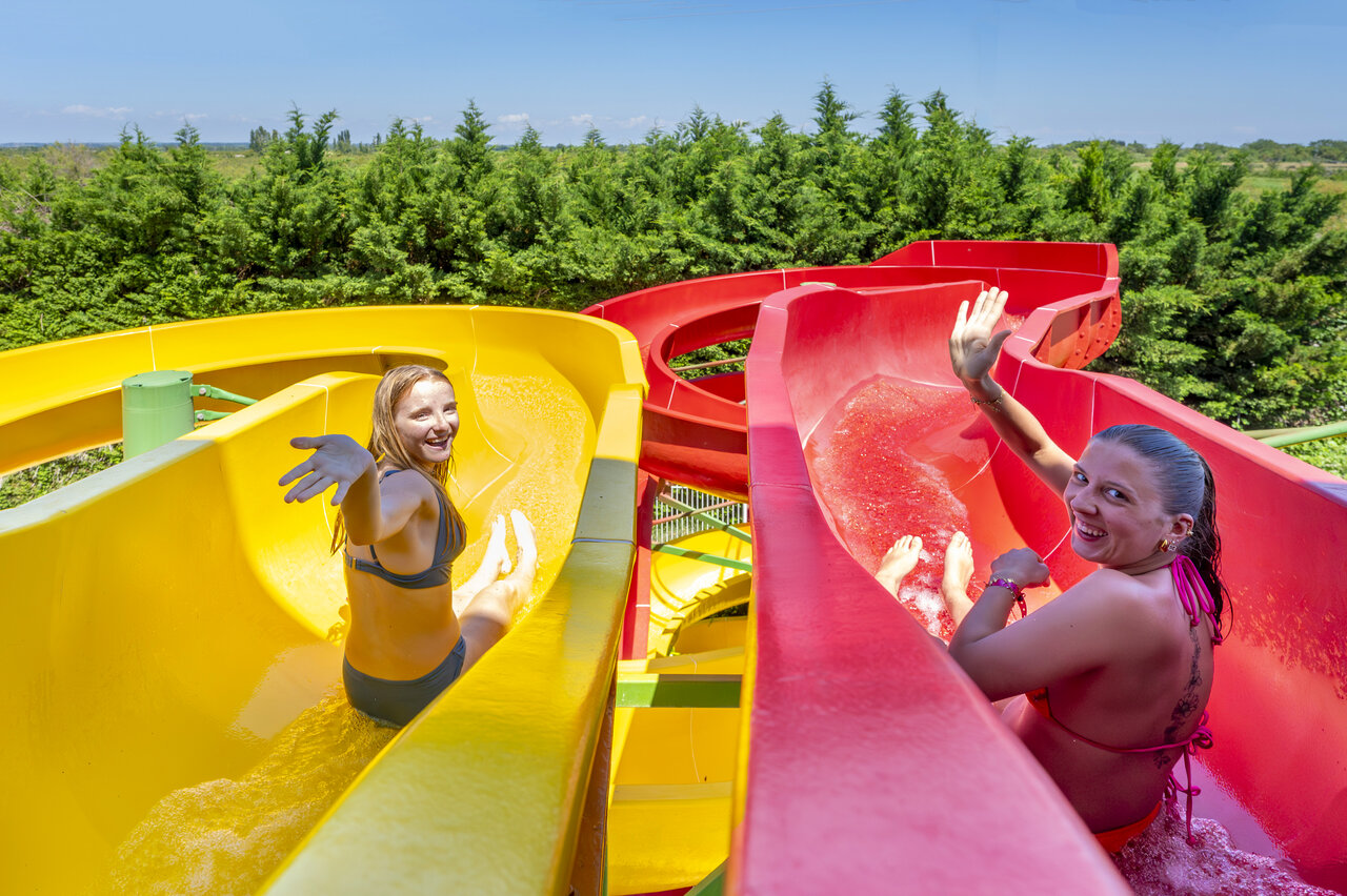 Dos mujeres sonrientes en toboganes acu�ticos en el camping CAPFUN Fleur de Camargue en Saint-Laurent-d Aigouze.