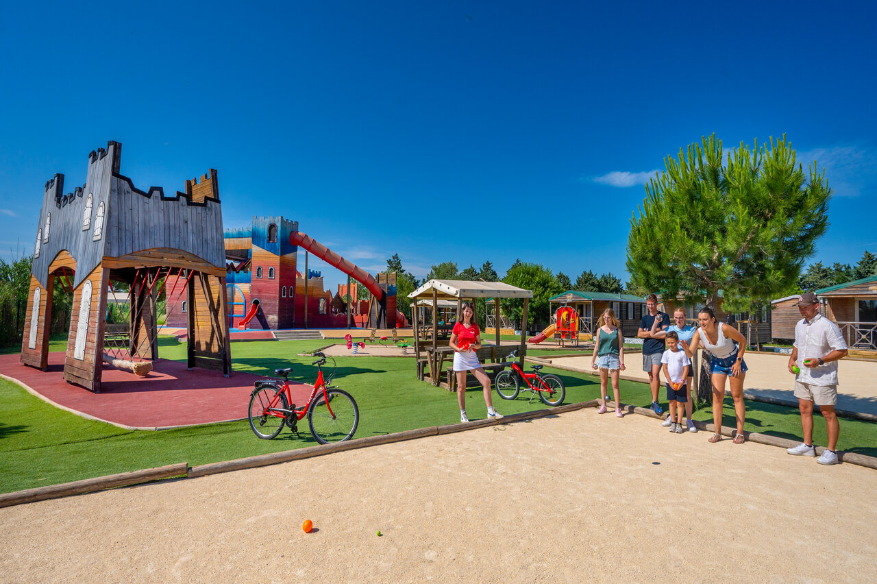 Parque infantil castillo, petanca y mobil-homes en el camping CAPFUN Fleur de Camargue en Saint-Laurent-d Aigouze (30).