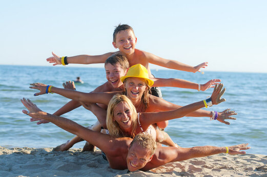 Familia sonriente en la playa del camping CAPFUN Fleur de Camargue en Saint-Laurent-d Aigouze (30).