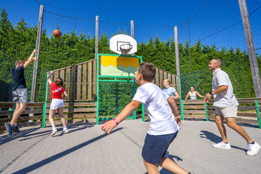 Pista multideporte con veraneantes jugando baloncesto en el camping CAPFUN Fleur de Camargue.