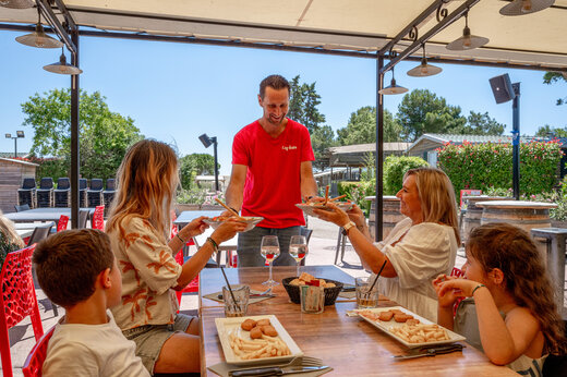 Familia almorzando en el restaurante del camping CAPFUN Fleur de Camargue.