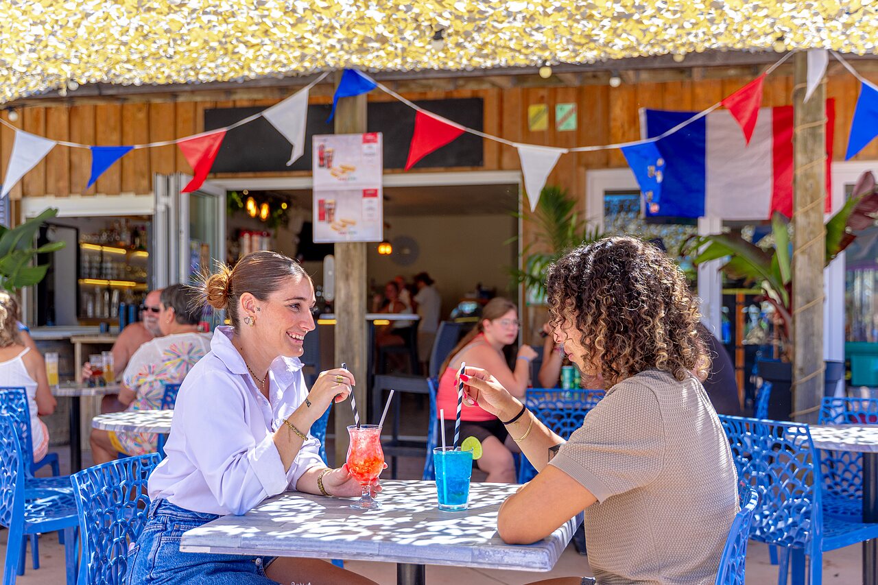 Bar exterior, clientes saboreando c�cteles en el camping CAPFUN Flots Bleus en VIAS PLAGE (34).