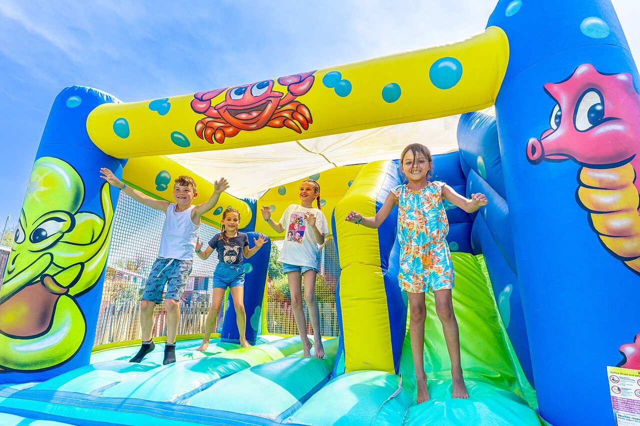 Ni�os divirti�ndose en castillo hinchable en el camping CAPFUN Flots Bleus en VIAS PLAGE (34).