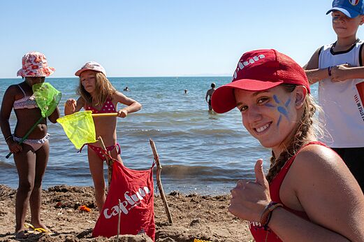 Ni�os jugando con redes en la playa, animadora sonriente en el camping CAPFUN Flots Bleus en VIAS PLAGE (34).