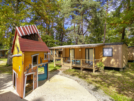 Zona de juegos infantil y Mobil-homes de madera en el camping CLICOCHIC La Forêt d'Azalée (91).