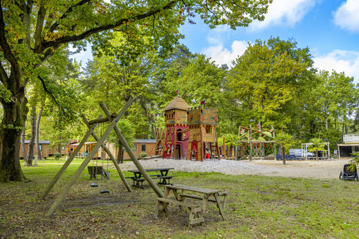 Zona de juegos castillo y columpios en el camping CLICOCHIC La Forêt d'Azalée en Saint-Chéron (91).