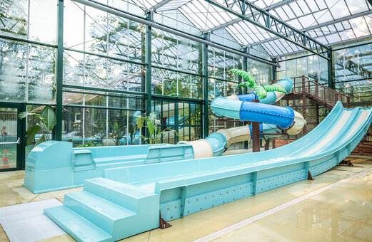 Piscina cubierta con toboganes acuáticos en el camping CLICOCHIC La Forêt d'Azalée.