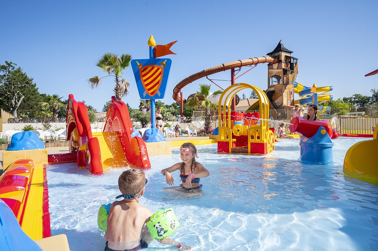 Zona de juegos acu�ticos con toboganes y ni�os en el camping CAPFUN Forges en Avrille (85).