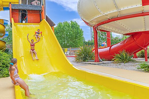 Ni�os en tobog�n acu�tico amarillo y rojo, piscina en el camping CAPFUN Forges en Avrille (85).