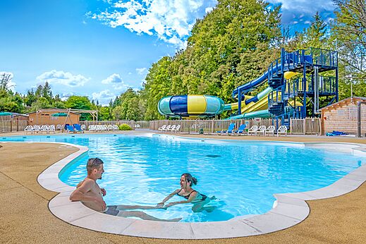 Piscina, toboganes y pareja en el camping CLICOCHIC Forge Sainte Marie en Thonnance-les-Moulins (52).