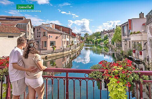 Joinville, ciudad turística con canal, casas antiguas y pareja admirando el paisaje.