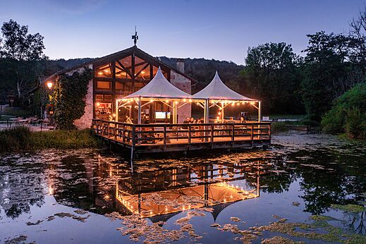 Restaurante-bar con terraza iluminada sobre el agua al camping CLICOCHIC Forge Sainte Marie.