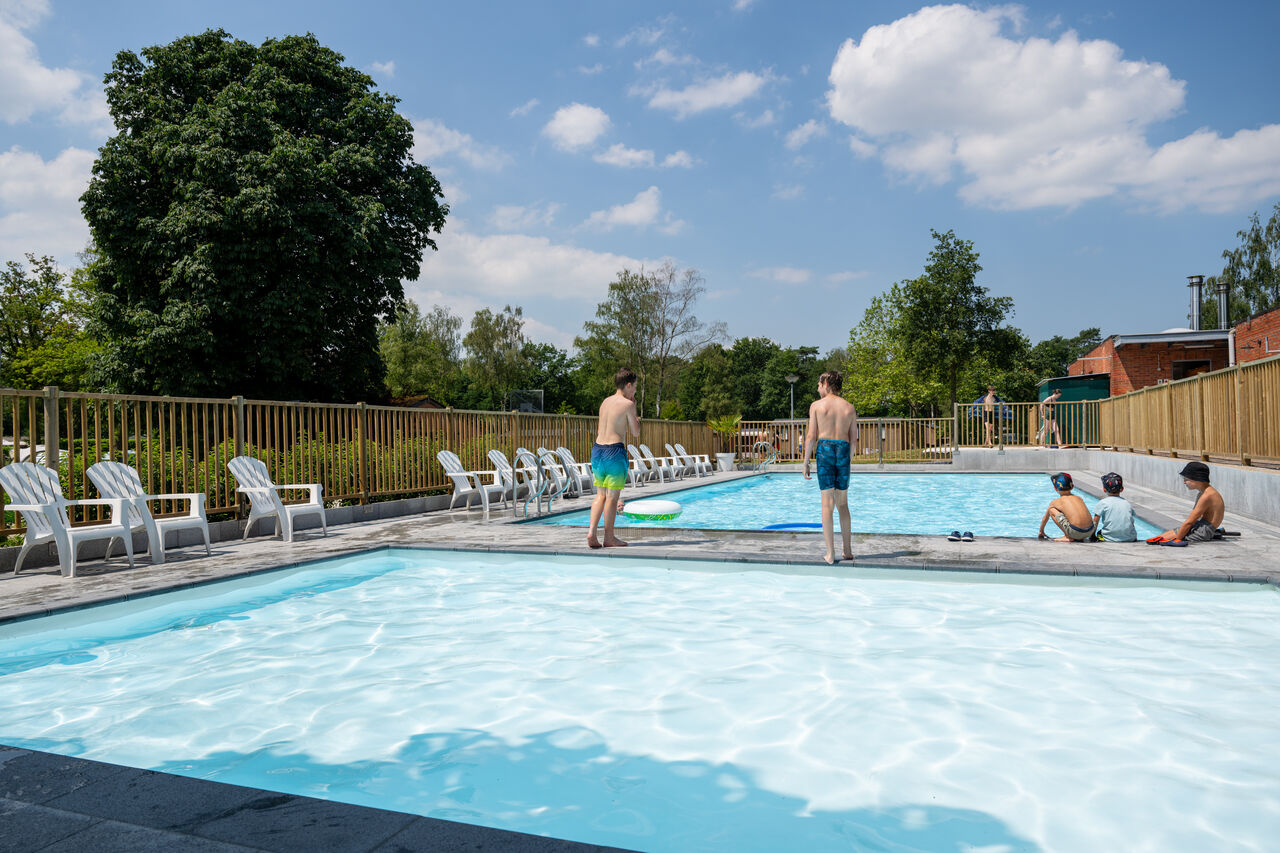 Piscina exterior, ni�os y tumbonas en el camping CAPFUN Fort Bedmar en Sint-Gillis-Waas.