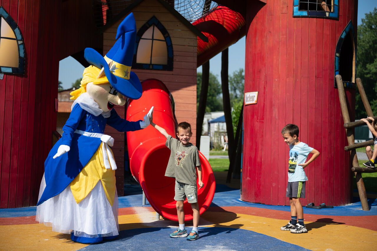 Mascota y ni�os jugando en el parque infantil con tobog�n en el camping CAPFUN Fort Bedmar en Sint-Gillis-Waas.