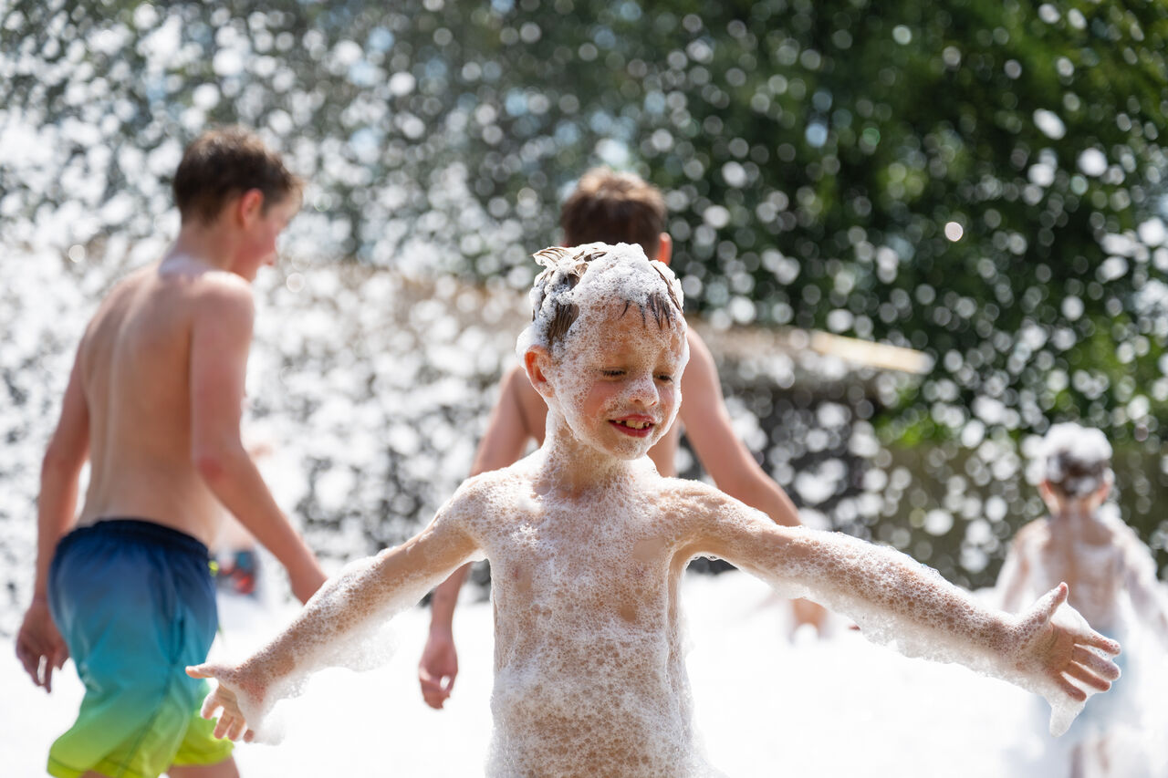 Ni�os felices jugando en una fiesta de espuma en el camping CAPFUN Fort Bedmar en Sint-Gillis-Waas.