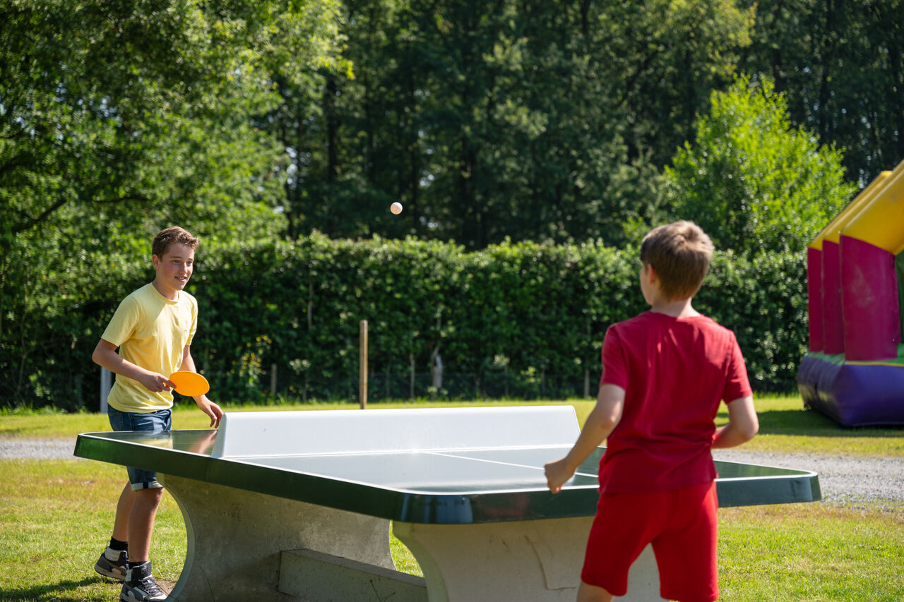 Dos ni�os jugando al ping-pong al aire libre en el camping CAPFUN Fort Bedmar en Sint-Gillis-Waas.