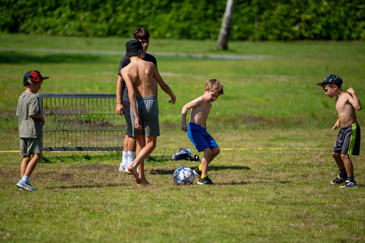 Ni�os jugando al f�tbol en un campo deportivo en el camping CAPFUN Fort Bedmar en Sint-Gillis-Waas.