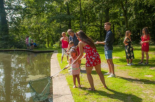 Familia pescando con cańas y red en estanque en el camping CAPFUN Fort Bedmar en Sint-Gillis-Waas.