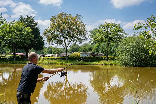 Hombre pescando en el estanque del camping CAPFUN Fort Bedmar en Sint-Gillis-Waas.