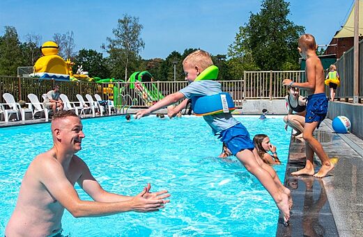 Nińo saltando en piscina, juegos acuáticos en camping CAPFUN Fort Bedmar.