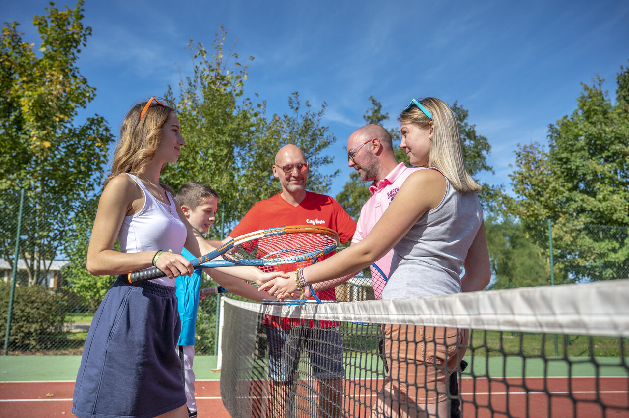 Familia y animadores jugando al tenis en el camping CAPFUN Fort Falabraque en Seltz.