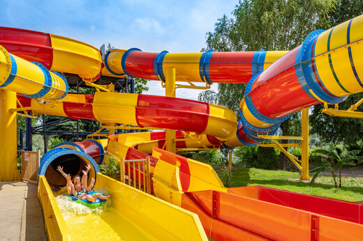 Toboganes acuáticos coloridos con gente en el camping CAPFUN Fort Falabraque en Seltz (67).