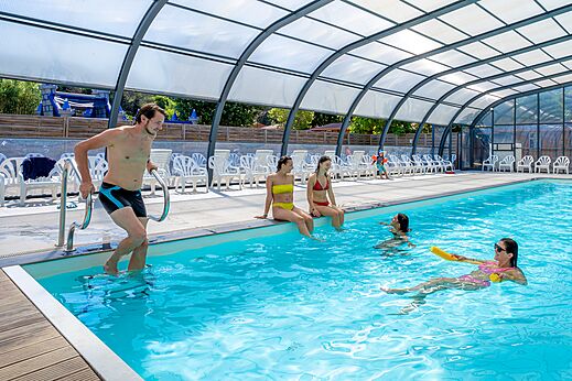 Piscina cubierta con bañistas disfrutando en el camping CAPFUN Le Fréjus en Fréjus (83).