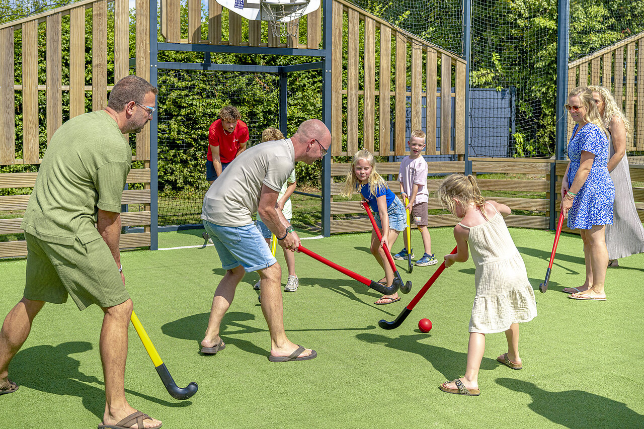 Familia jugando al hockey sobre c�sped sint�tico en el camping CAPFUN De Fruithof en Klijndijk.