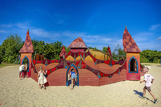 Castillo de juegos de madera en arena para niños en el camping CAPFUN De Fruithof en Klijndijk.
