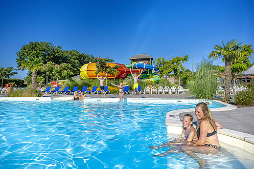 Piscina exterior, toboganes acuáticos coloridos en el camping CAPFUN De Fruithof en Klijndijk.