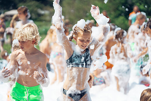 Niños felices en la fiesta de la espuma en el camping CAPFUN De Fruithof en Klijndijk.
