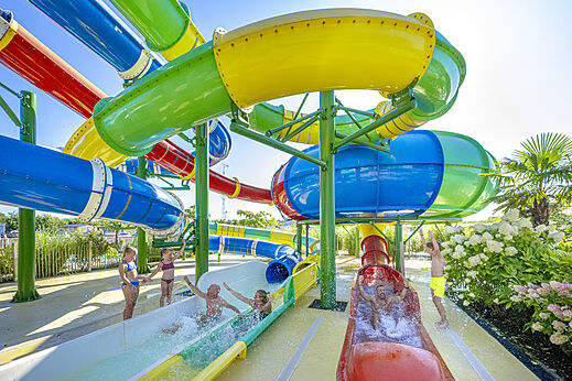Toboganes acuáticos gigantes y coloridos con niños en el camping CAPFUN De Fruithof en Klijndijk.