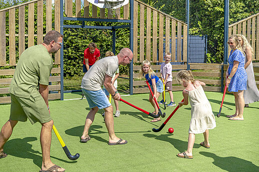 Familia jugando hockey hierba en el camping CAPFUN De Fruithof en Klijndijk.