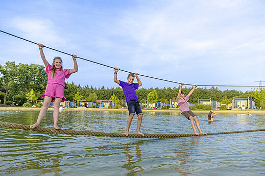 Niños divirtiéndose en un recorrido acuático en el camping CAPFUN De Fruithof en Klijndijk.
