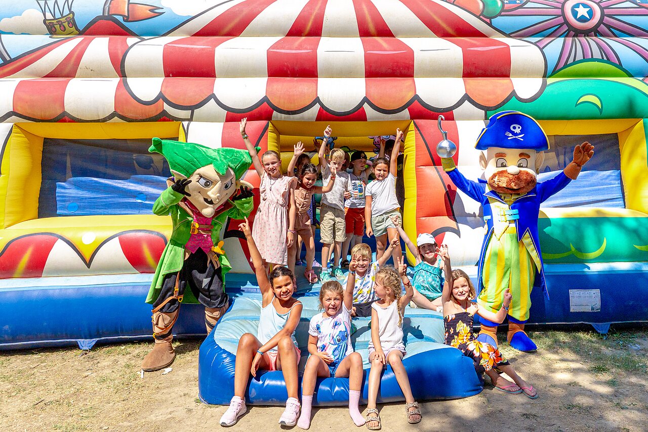 Ni�os y mascotas frente a un castillo hinchable en el camping CAPFUN Fumades en ALLEGRE-LES-FUMADES.
